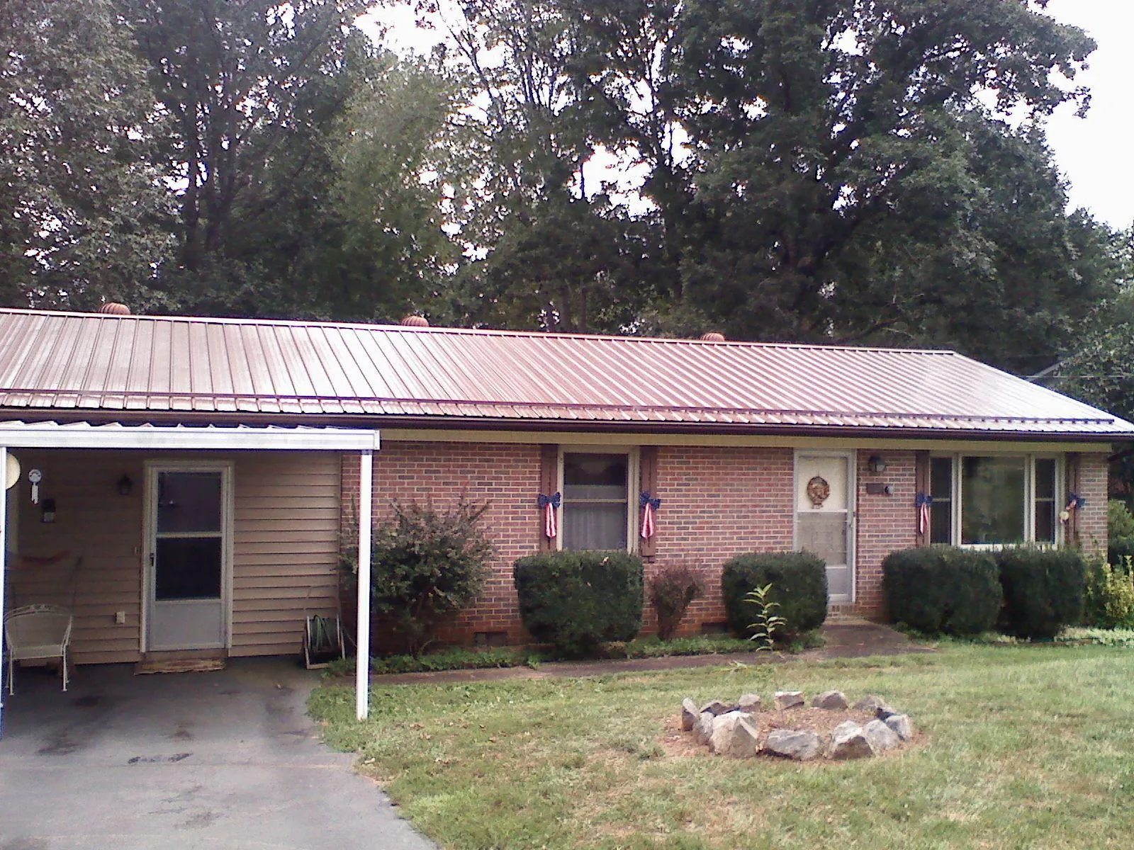 Bronze metal roof and carport on a brick ranch home — Roof Repair work by our crew in Gotha